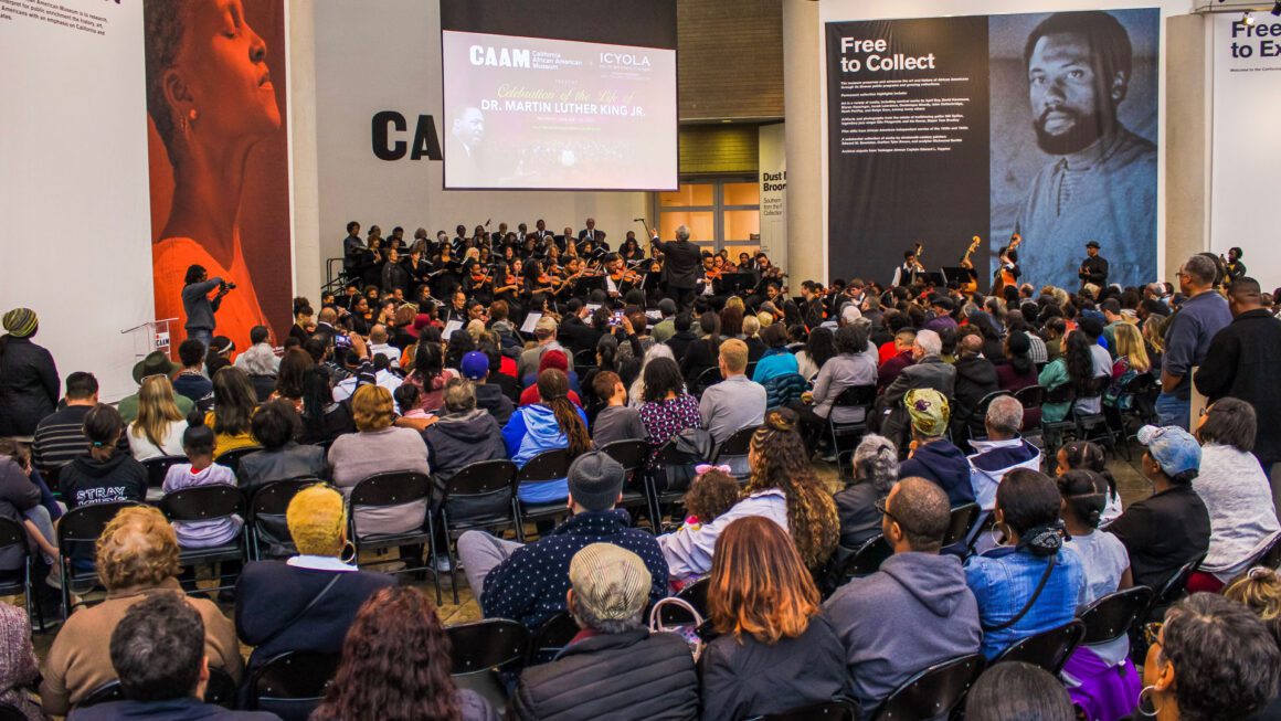 A crowd of people sitting in chairs watching a presentation.